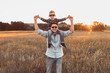 © kieferpix - Family father and son in a field at sunset, surrounded by nature's beauty.