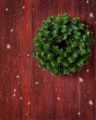 Wall Mural - Christmas wreath on old red wooden background.