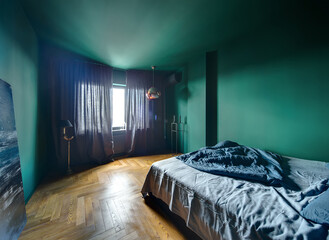 Wall Mural - Bedroom in a modern style with turquoise walls and a parquet on the floor. There is a bed with blue pillow and blanket, blue picture, lamps, stand with candlestick, window with curtains, conditioner.