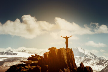 Wall Mural - Man in winner pose with raised hands stands on the top of mountains. Win concept