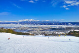 Fototapeta Dziecięca - 快晴の富良野スキー場から見る十勝岳連峰、北の峰ゾーンの広大な初心者コースを滑るスキーヤー達

