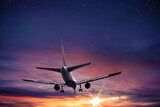 Fototapeta Na sufit - Aircraft flies in the sky at sunset