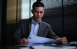 © wattana - Concentrated businessman reading contract, partnership agreement and working in modern office.