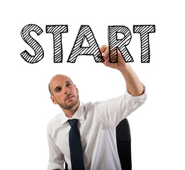 Wall Mural - Businessman writing the word start with a pen