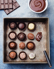 Chocolate candies in a vintage baking dish with chocolatier tool