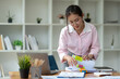 © Phimwilai - Asian businesswoman working in piles of paper files Documents in the meeting to search and review the various work folders at the desk to record information. management concept