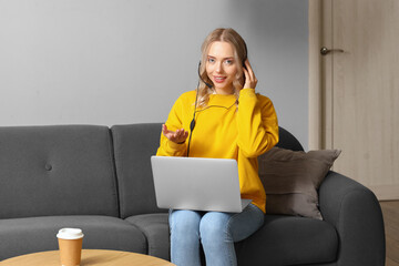 Wall Mural - Female technical support agent with laptop working at home