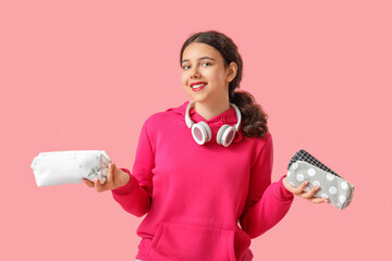 Canvas Print - Female student with pencil cases on pink background