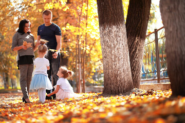 Leaf fall in the park. Children for a walk in the autumn park. Family. Fall. Happiness.