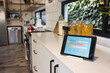 © Wavebreak Media - Tablet with smart home interface on white worktop in kitchen