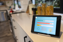 Tablet With Smart Home Interface On White Worktop In Kitchen