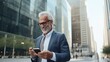 © WS Studio 1985 - Stylish classy older mature adult professional business man, senior old bearded businessman executive holding smartphone, using mobile tech on cell phone standing outside big city, generative ai
