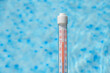 Termometr pokazujący wysoką temperaturę na tle basenu ogrodowego
