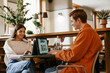 © Drobot Dean - Couple working on laptops while sitting in cafe