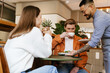 © Drobot Dean - Young asian waiter serving couple in cafe