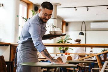 Wall Mural - Waiter cleaning table in cafe