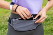 Fitness runner woman getting ready for running with smartwatch and smartphone holder fanny pack waist belt. Athlete woman wearing wearable tech activity tracker for sport exercise activity.