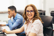 © Mediteraneo - Portrait of a modern businesswoman smiling and looking at the camera while sitting in her office