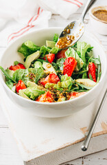 Wall Mural - Summer strawberry salad with avocado, lettuce with honey mustard sauce.