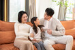 © Blue Jean Images - Happy young Chinese family sitting on sofa
