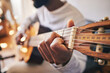 © Malik/peopleimages.com - Closeup, hands of man and guitar for music, live talent and creative skill of sound production in home studio. Musician, singer or artist playing notes on acoustic instrument in solo jazz performance