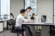 © Blue Jean Images - Confident Chinese business people talking in office