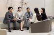 © Blue Jean Images - Confident Chinese business people talking in meeting room