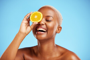 Wall Mural - Orange, beauty and funny with a model black woman in studio on a blue background for natural nutrition. Fruit, skincare and smile with a happy young female person laughing for health or wellness