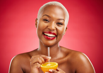 Wall Mural - Happy black woman, portrait and orange for vitamin C, diet or natural nutrition against a red studio background. African female person smile and drinking organic citrus fruit with straw on mockup