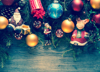 Wall Mural - Merry Christmas Frame with real wood green pine, colorful baubles, gift boxe and other seasonal stuff over an old wooden aged background