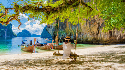 Wall Mural - women on a swing at the Tropical lagoon of Koh Loa Lading Krabi Thailand part of the Koh Hong Islands in Thailand. beautiful beach with limestone cliffs and longtail boats