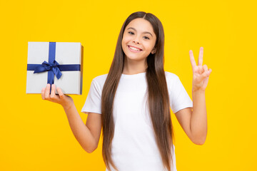 Happy teenager portrait. Emotional teenager child hold gift on birthday. Funny kid girl holding gift boxes celebrating happy New Year or Christmas. Smiling girl.