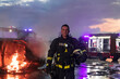 Portrait of a heroic fireman in a protective suit. Firefighter in fire fighting operation.