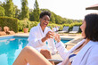 © Monkey Business - Two Mature Female Friends Wearing Robes Outdoors On Loungers Drinking Champagne On Spa Day