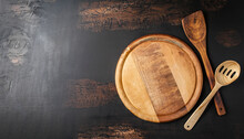 Abstract Food Background. Top View Of Dark Rustic Kitchen Table With Wooden Cutting Board And Cooking Spoon, Frame. Banner Or Template With Copy Space For Your Design. Kitchen Utensils Objects