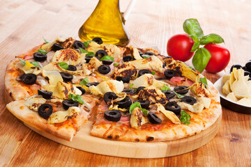 Wall Mural - Delicious pizza background. Fresh pizza, olive oil, on wooden background. Culinary pizza eating.