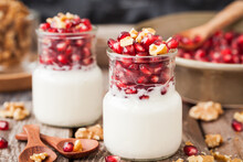 Fresh Plain Yogurt With Pomegranate Seeds And Walnut In A Glass Jars For Breakfast