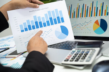 Wall Mural - Asian accountant working and analyzing financial reports project accounting with chart graph in modern office, finance and business concept.