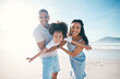 © Wesley JvR/peopleimages.com - Beach, portrait and parents flying their kid on the sand by the ocean on a family vacation. Happy, smile and girl child playing and bonding with her young mother and father on tropical summer holiday