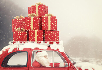 Canvas Print - Santa Claus drives a red car full of Christmas present