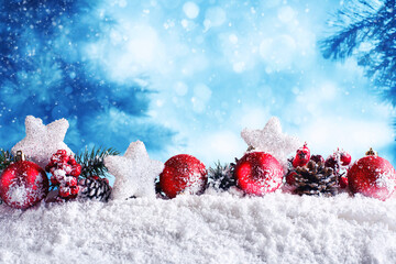 Red Christmas balls with stars and garlands on snow