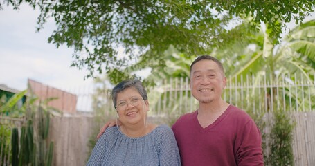 Happy loving couple Asian family elderly husband and wife talking smiling and laugh together in the park, Retirement senior couple relax and enjoy romantic outdoor lifestyle vacation together.