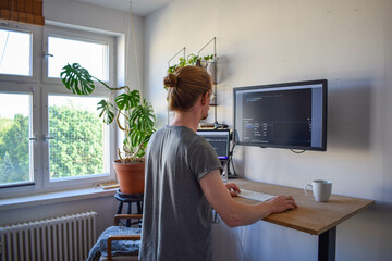 young businessman working on stand up desk computer studying business ideas on a pc screen on-line..