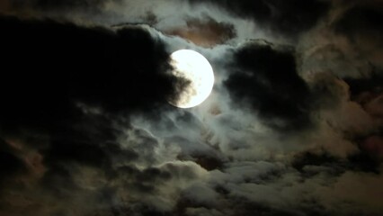 Wall Mural - Moon in the blue clouds of the night sky. Clouds fly in front of the full moon. Mysterious Halloween Night