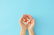 Disease treatment concept. First person top view photo of capsules and tablets in women hands on pastel blue background