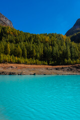  Autumnal landscape of the Lake Place Moulin, an artificial glacial lake with turquoise water in the italian Alps,  on the border with Switzerland