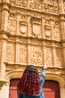 © Sangiao_Photography - Looking for the frog and skull in Salamanca university plateresque facade. Latin middle-aged woman