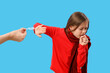 Ill little girl rejecting cough syrup on blue background