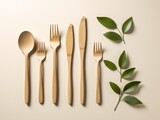 Fototapeta  - Wooden decomposable forks, spoons and knives on a light surface with green leaves.conceptual ecology and recycling problem.flat lay. Generative AI