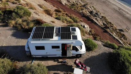 Canvas Print - Aerial view. Camper car  with solar photovoltaic panels on roof camping on cliff sea shore. Mediterranean region of Villaricos, Almeria, eastern Andalusia, Spain.